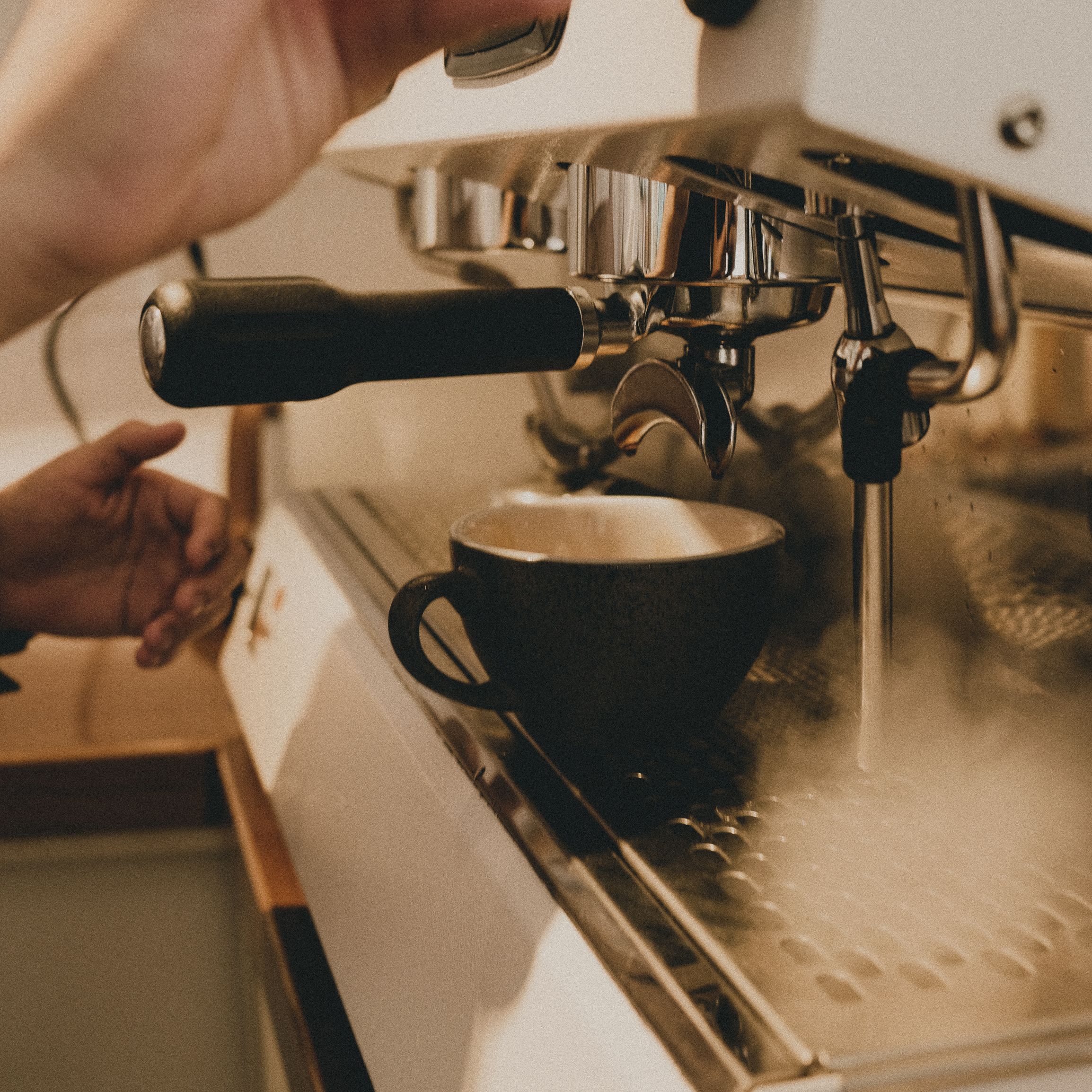 Barista preparing coffee on a professional espresso machine during service