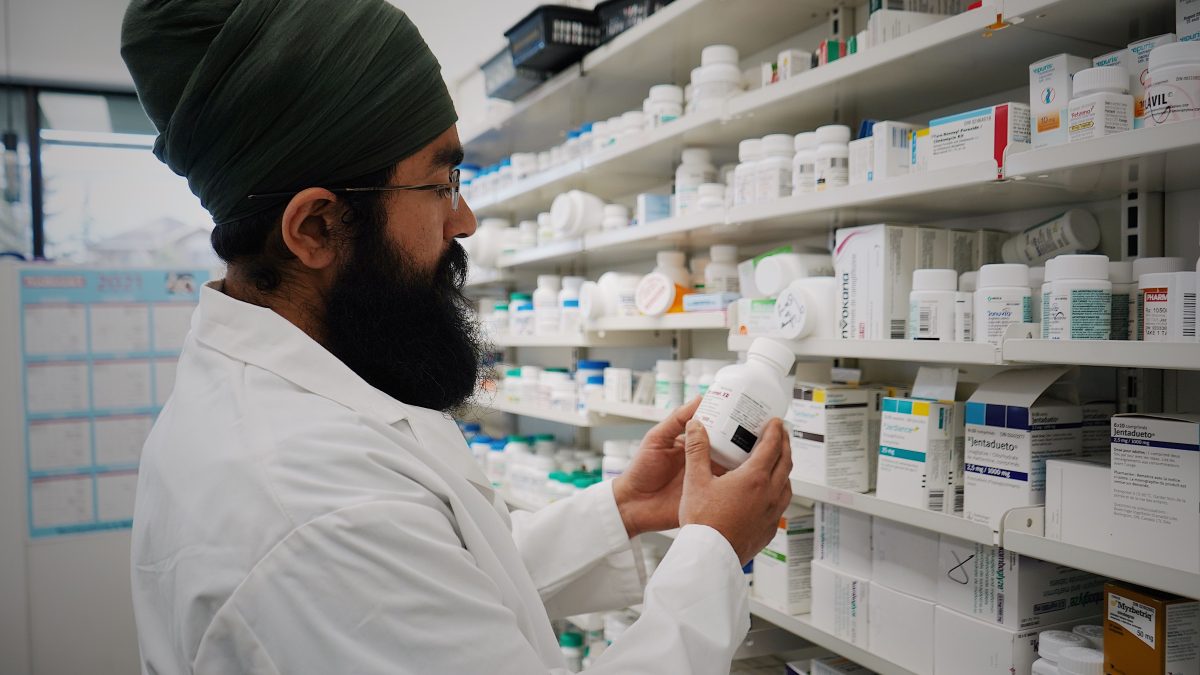 Pharmacist organizing shelves of medicine in a pharmacy