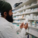 Pharmacist organizing shelves of medicine in a pharmacy