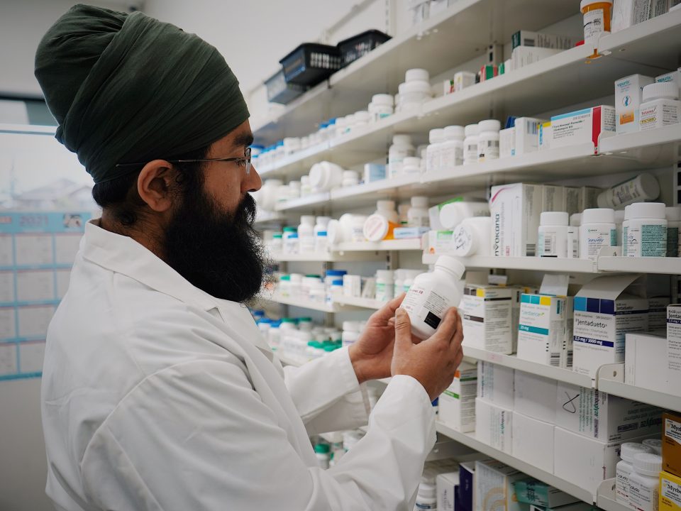 Pharmacist organizing shelves of medicine in a pharmacy
