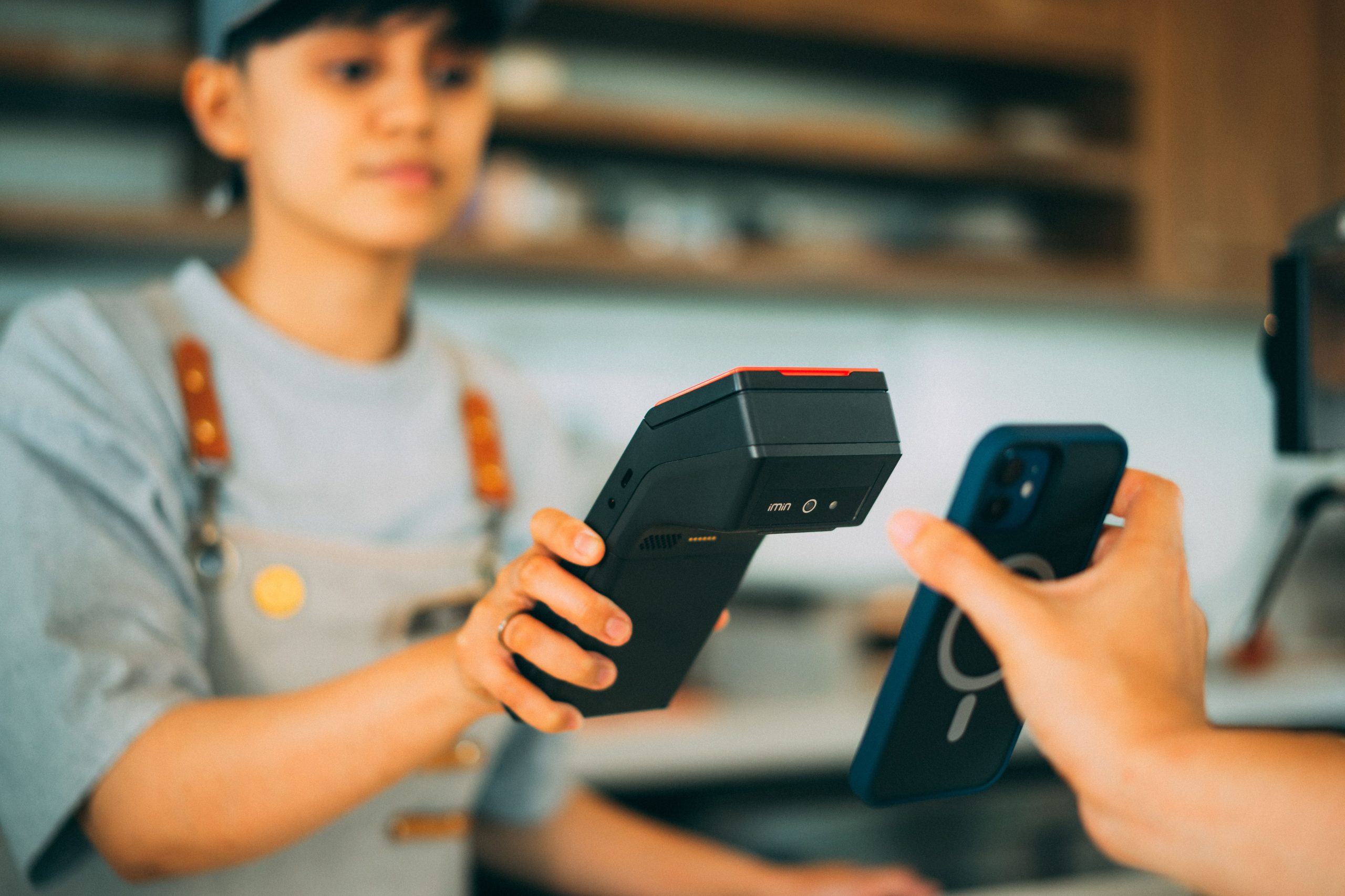 Cashier processing a contactless payment using a card reader