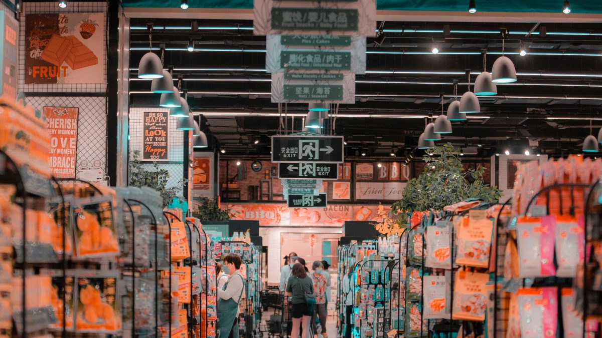 Bustling supermarket aisle with shoppers and stocked shelves