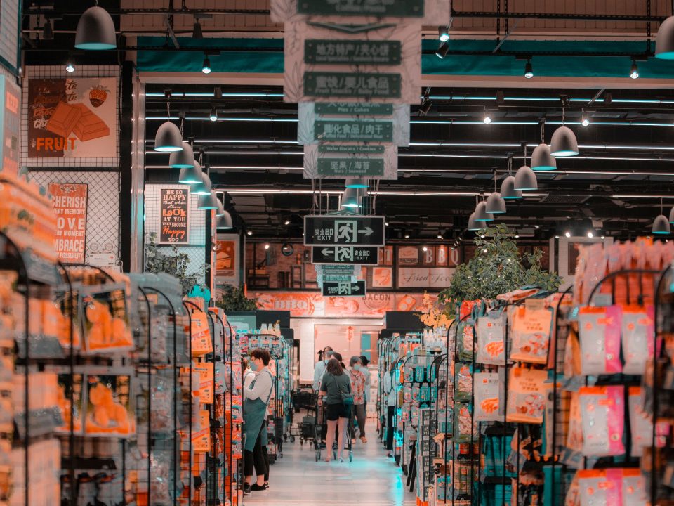 Bustling supermarket aisle with shoppers and stocked shelves