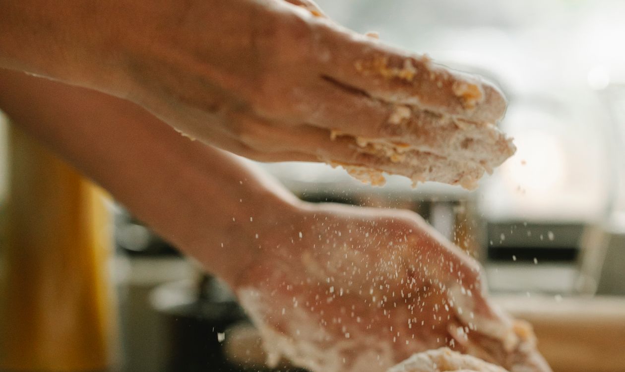 How Bakery POS Software Reduces Daily Waste and Manages Custom Cake Orders 7 Baker kneading dough on a floured surface in a bakery kitchen