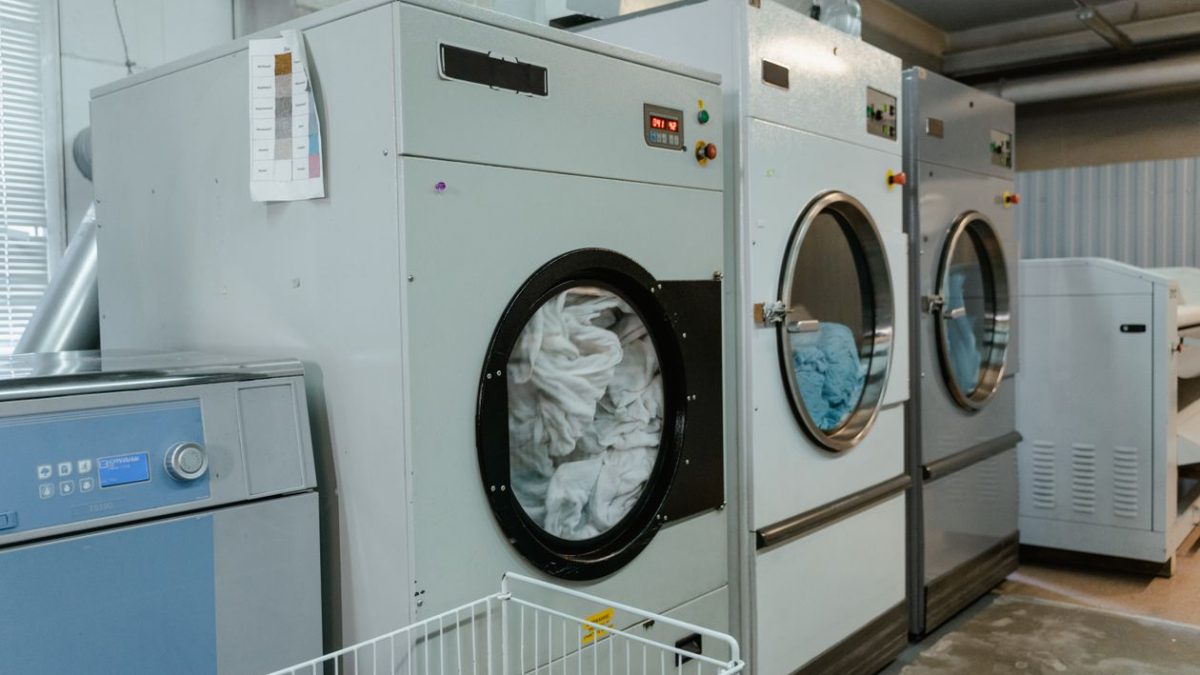 Row of industrial washing machines in a commercial laundry facility