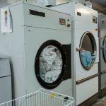 Row of industrial washing machines in a commercial laundry facility
