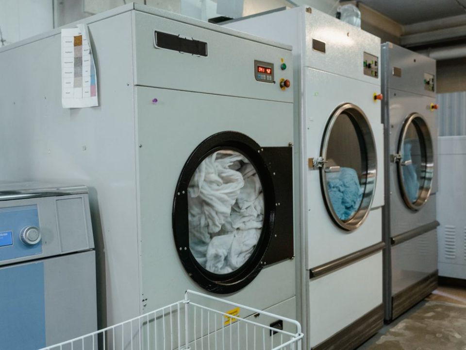 Row of industrial washing machines in a commercial laundry facility