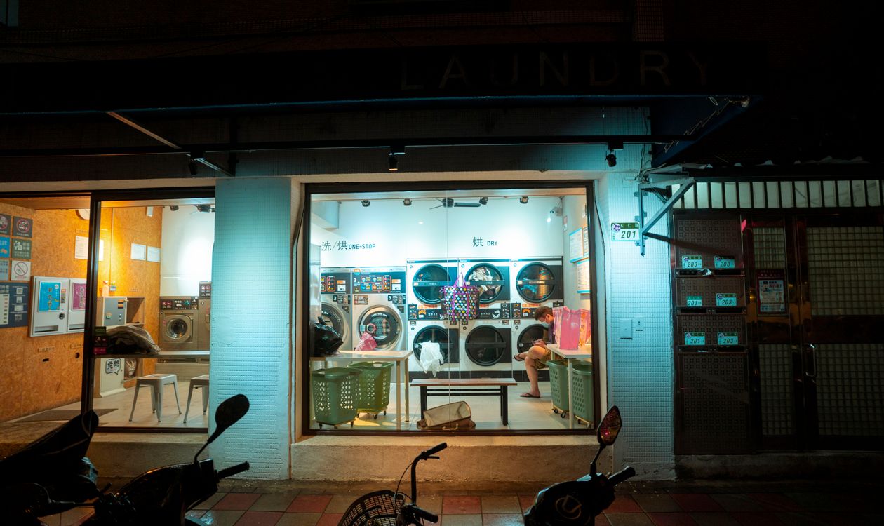 How Laundry POS Software Prevents Lost Garments and Missed Deliveries 8 Laundry shop interior at night with lit modern washing machines
